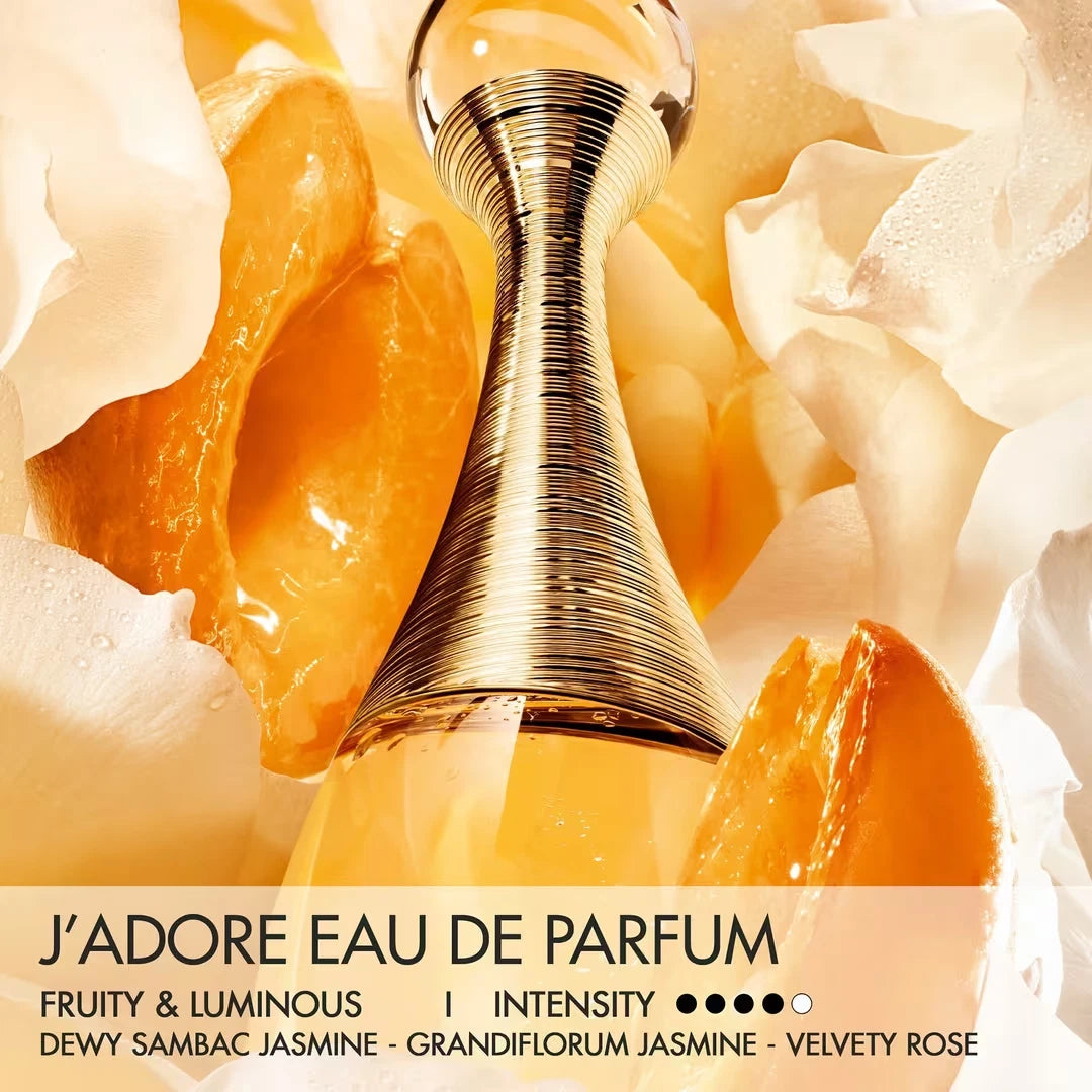 Gold perfume bottle with floral and fruit elements on a yellow background
