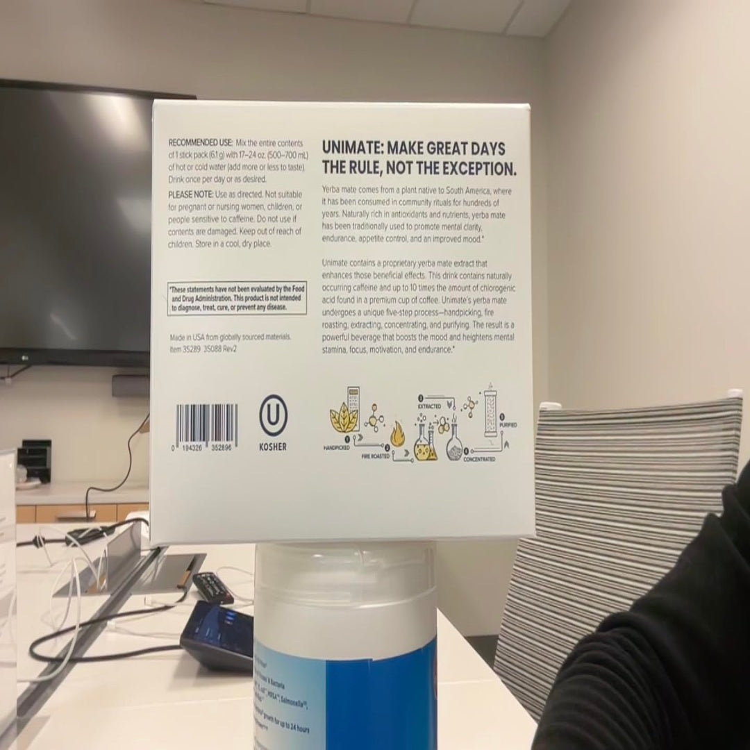 Back of a container with text and branding, placed on a desk.