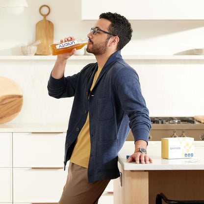Man drinking from a Univea container in a kitchen