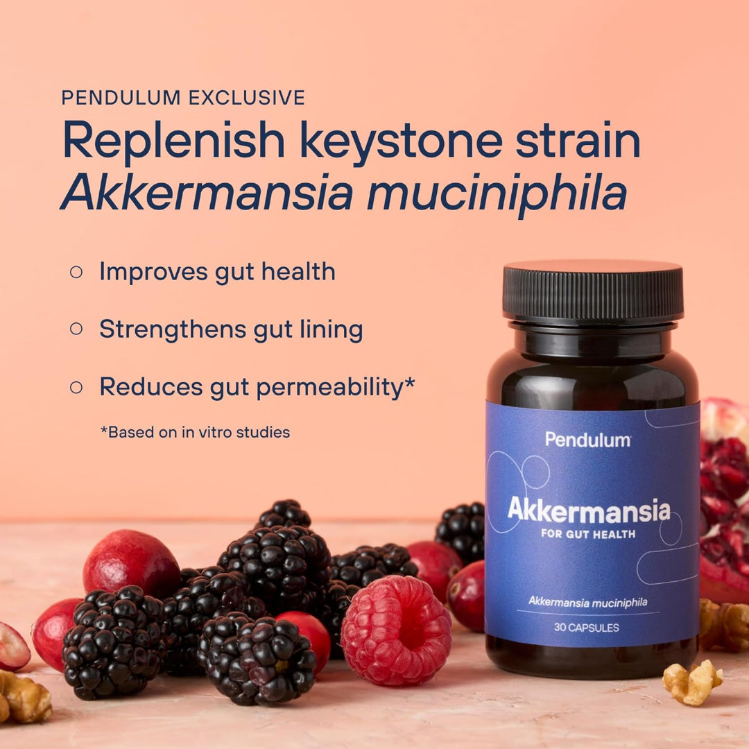 Bottle of Pendulum Akkermansia supplement with berries and nuts on a wooden surface