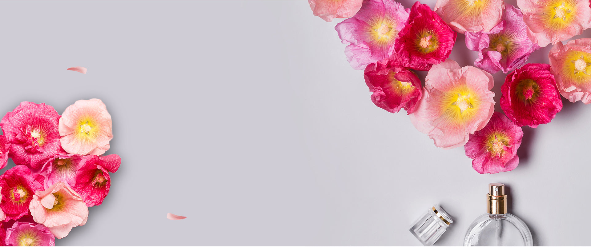 Floral arrangement with a perfume bottle on a light gray background