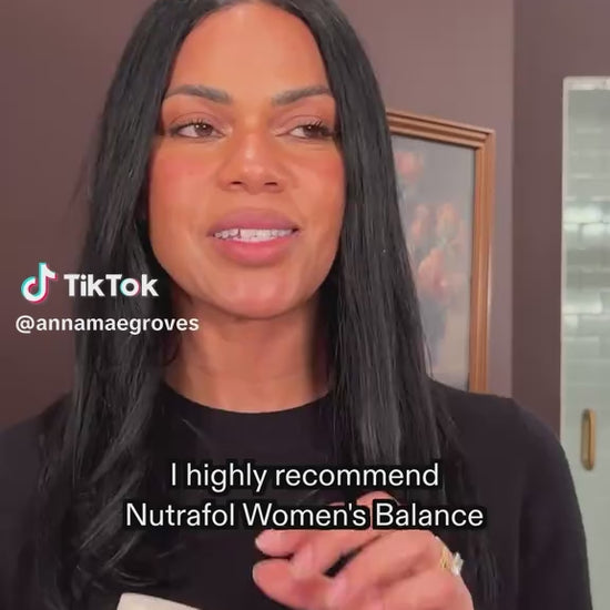 Nutrafol hair growth supplement bottle with pills and water on a wooden surface, labeled as a dermatologist-recommended brand.
