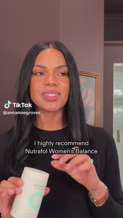 Nutrafol hair growth supplement bottle with pills and water on a wooden surface, labeled as a dermatologist-recommended brand.