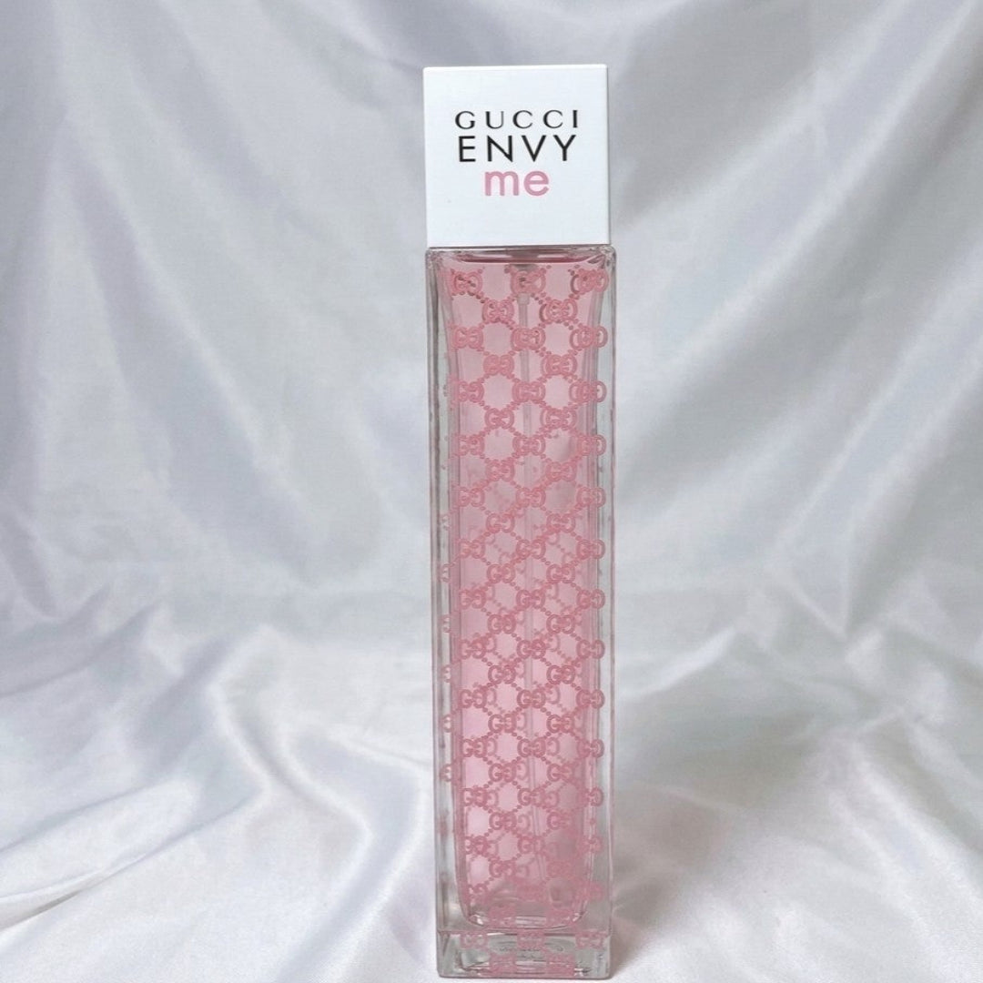 Gucci Envy me perfume bottle with pink pattern on a white background