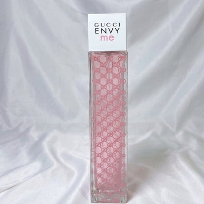 Gucci Envy me perfume bottle with pink pattern on a white background