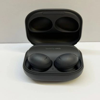 Black wireless earbuds in an open case on a white surface