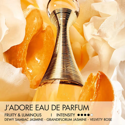 Gold perfume bottle with floral and fruit elements on a yellow background